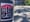 A Hell Gate Sticker on a lamppost in front of a sun-dappled city playground