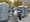 A man places a dollar bill into a trash can-turned-tip jar before using one of the port-a-potties at the base of the Brooklyn