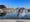 A dolphin's head superimposed over a photo of Newtown Creek, on a sunny day.